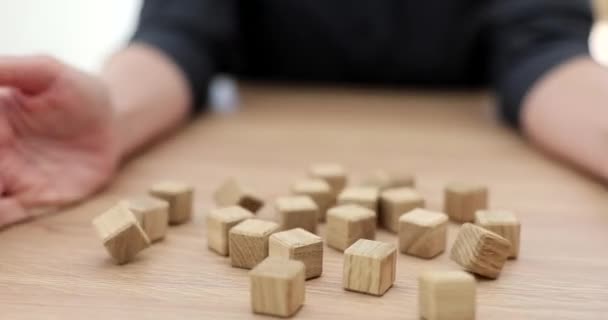 Handen gooien houten blokjes op tafel, close-up. Intellectueel spel, ontwikkeling van logica, oppervlakkige focus - Video