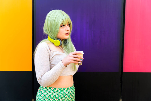 Modern meisje met groen haar drinken in cafe op de universiteit - Foto, afbeelding