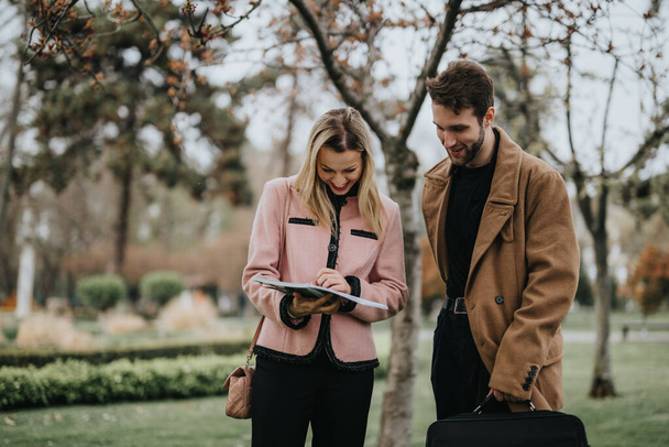 A dynamic duo of young professionals discussing business strategies and marketing trends in a park setting, analyzing growth potential. - Photo, Image