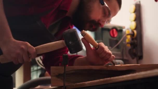 Artisan χρησιμοποιώντας μέγγενη πάγκου για να κρατήσει το ξύλο μπλοκ, σκάλισμα περίπλοκα σχέδια σε ξύλο χρησιμοποιώντας σμίλη και σφυρί. Καλλιτέχνης χρησιμοποιεί εργαλείο vice να σφιγκτήρα κομμάτι ξύλου, διαμόρφωση καταγραφής με εργαλεία, φωτογραφική μηχανή - Πλάνα, βίντεο