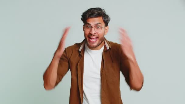 Irritated angry Indian man screams from stress tension problems feels horror hopelessness fear surprise shock expresses rage nervous, quarrel. Arabian young guy isolated on gray studio background - Footage, Video
