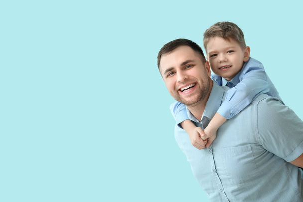 Glücklicher Vater und sein kleiner Sohn haben Spaß auf blauem Hintergrund - Foto, Bild