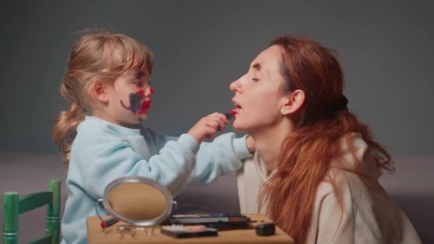 Маленькая девочка наносит макияж своей матери. время, проведенное с ребенком. - Кадры, видео