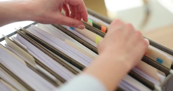 Gestionnaire comptable trie les dossiers dans un tiroir en papier. Rechercher des documents commerciaux et concept d'archive - Séquence, vidéo