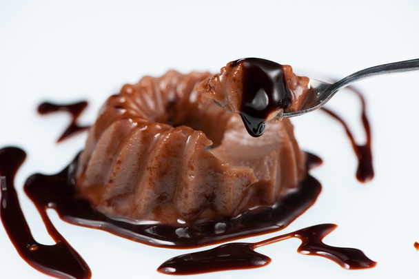 Chocolate pudding with chocolate dressing on white plate - Photo, image