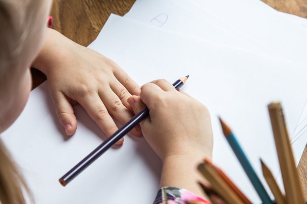 Kleine meisje afbeeldingen tekenen met potloden - Foto, afbeelding
