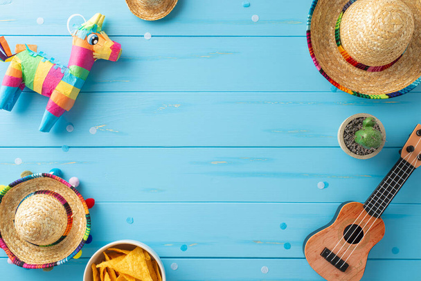 Cinco de Mayo temalı ekran: parlak ahşap arka planda sombreros, vihuela, kaktüs, lama pinata, nachos ve konfeti manzarası. Promosyon malzemeleri için mükemmel. - Fotoğraf, Görsel