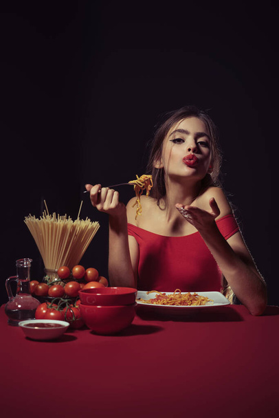 Seksowna kuchnia. Seksowna kobieta w kuchni gotuje makaron. Włoska koncepcja makaronu. Homoseksualny makaron miłości. Makaron albo spaghetti. Zmysłowa kobieta jedząca spaghetti. Obraz pięknej kobiety jedzącej makaron - Zdjęcie, obraz