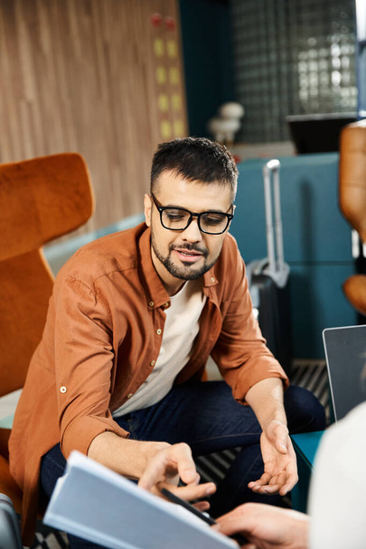 Muž v brýlích sedí na gauči, zabraný do laptopu. - Fotografie, Obrázek