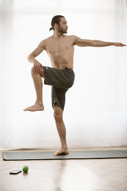 Handsome man practices yoga on a mat at home. - Photo, Image