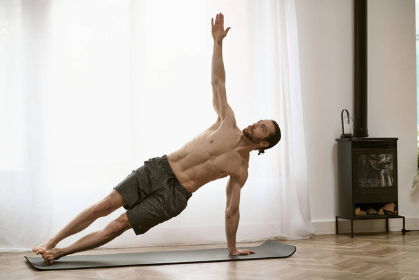 Красивый мужчина в своей утренней рутине, практикующий йогу на коврике. - Фото, изображение