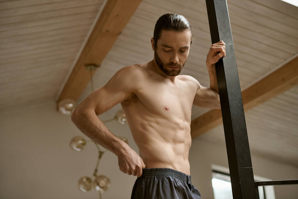 Мужчина без рубашки тонизирует мышцы дома. - Фото, изображение
