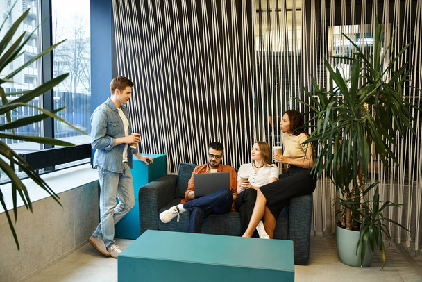 Un grupo diverso de colegas en un espacio de coworking moderno, sentados en sofás elegantes, participando en una animada discusión. - Foto, Imagen