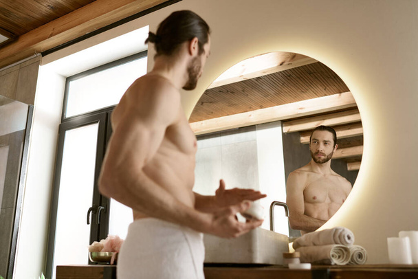 Jóképű férfi a fürdőszobában, reggeli bőrápoló gyakorlattal és tükör előtt ápolással.. - Fotó, kép