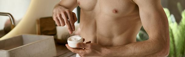 Чоловік без сорочки впевнено наносить крем під час виконання ранкової процедури. - Фото, зображення