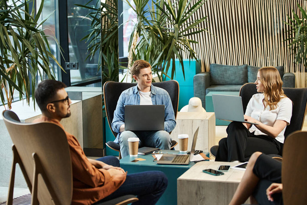 Collega 's in de co-working ruimte, een startup team bespreken ideeën en werken op laptops rond een tafel. - Foto, afbeelding