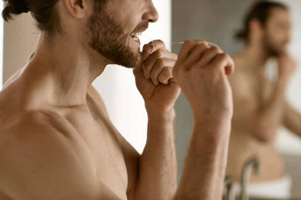 Knappe man poetsen tanden in badkamer spiegel. - Foto, afbeelding