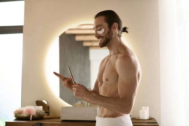 A handsome man in a towel with nail file. - Photo, Image