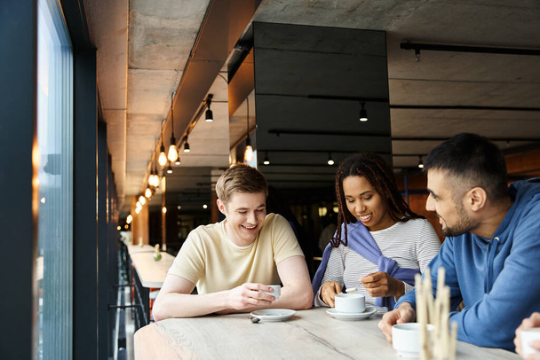 Un grupo diverso de colegas de un equipo de startups disfrutando de un café juntos alrededor de una mesa en un espacio de coworking. - Foto, Imagen