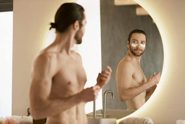 Hemdloser Mann untersucht sich selbst im Spiegel während der Morgenroutine. - Foto, Bild