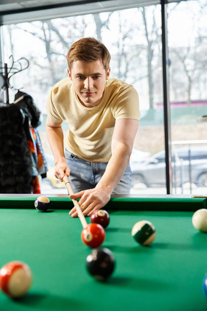 Een man van een coworking startup team speelt pool in een kamer, het nemen van een pauze van de moderne zakelijke levensstijl. - Foto, afbeelding