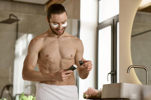 Um homem em uma toalha usando desodorizante em uma casa de banho. - Foto, Imagem