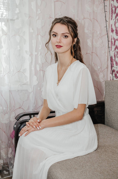 la novia en un vestido de novia está sentado en el sofá - Foto, Imagen
