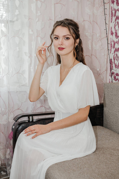 la novia en un vestido de novia está sentado en el sofá - Foto, Imagen