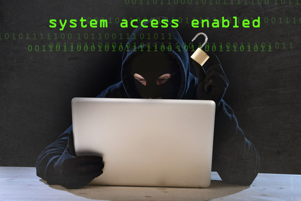 dangerous hacker man with computer and lock hacking system in cyber crime concept - Photo, Image