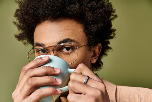 Un uomo sofisticato con gli occhiali che si gode una tazza di caffè. - Foto, immagini