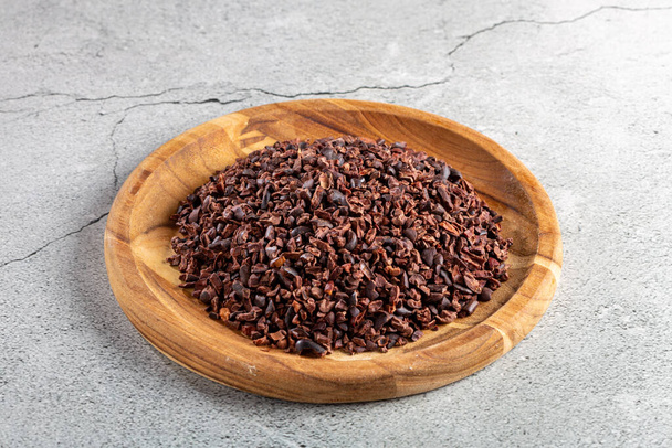 Cocoa nibs on wooden plate. - Photo, Image