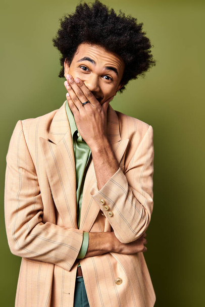 Komea afroamerikkalainen mies tyylikkäässä puvussa, syvällä mietiskelyssä kädet suunsa päällä. - Valokuva, kuva