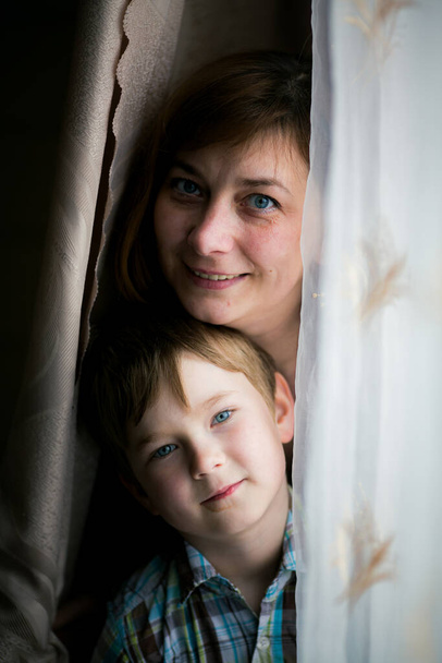 Portrait of a woman with her young son playing in the room. - Photo, Image