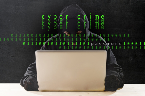 サイバー犯罪やサイバー犯罪概念のコンピューターとマスクとフードのハッカー - 写真・画像