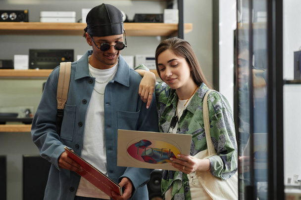 Pas se portrét usmívající se mladý pár výběru vinylových desek v hudebním obchodě - Fotografie, Obrázek