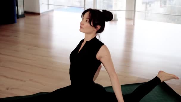 Спокійна жінка тренується з медитацією йоги для психічного здоров'я та розтягування. Жінка, що виконує позу Ека Пада Раджапотасани. Красива жінка в спортивному одязі практикує різні позу асан на килимку - Кадри, відео