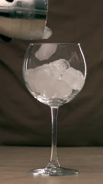 Μακρύ ανθρακούχο ποτό στο κλαμπ. Μαγειρεύω ένα κοκτέιλ Άπερολ Σπριτζ. Κοντινό πλάνο μπάρμαν χέρια ρίχνει aperol σε ποτήρι κρασιού με πάγο, ανάμειξη κοκτέιλ. Κάθετη βίντεο - Πλάνα, βίντεο