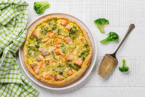 Verse vis zelfgemaakte taart met zalm en broccoli. Vlakke plaat - Foto, afbeelding