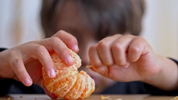 Atención al detalle: Youngster elimina meticulosamente las fibras antes de disfrutar de su mandarina - Metraje, vídeo