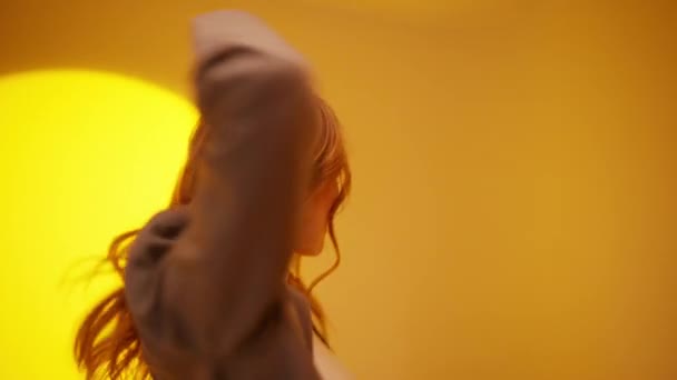Fancy młoda kobieta 20s lat taniec głupiec wokół zabawy gestykulacji z rąk cieszyć się relaks odizolowany na neon żółty tło studio - Materiał filmowy, wideo