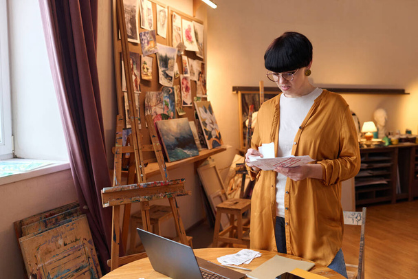Талия портрет владелицы женского бизнеса сортировки счетов и налогов при управлении финансами в художественной студии, копировать пространство - Фото, изображение