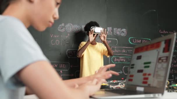 Nahaufnahme eines Handcodierungsprogramms für Schulmädchen, während afrikanische Schüler mit VR mit metaworld interagieren. Kluger Junge mit Virtual-Reality-Brille und Videospielen in innovativer Klasse. Erbauung - Filmmaterial, Video