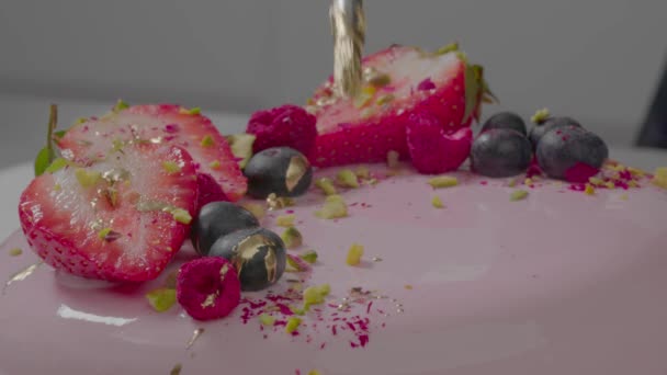 Pastel cremoso rosa con frutas. Dulce postre para las vacaciones de cumpleaños, publicidad de nuevo café de panadería. Concepto de confitería. Agregando el último ingrediente. Cierra el pastel de frutas. Imágenes de alta calidad 4k - Metraje, vídeo
