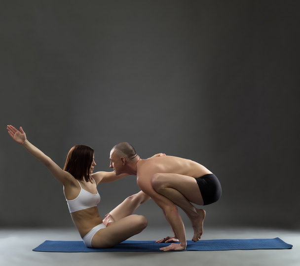 Yoga. Image of trainers posing in difficult asana - Фото, изображение
