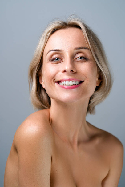 Natural beauty. Blonde woman with healthy skin.  No makeup. Grey background. - Foto, afbeelding