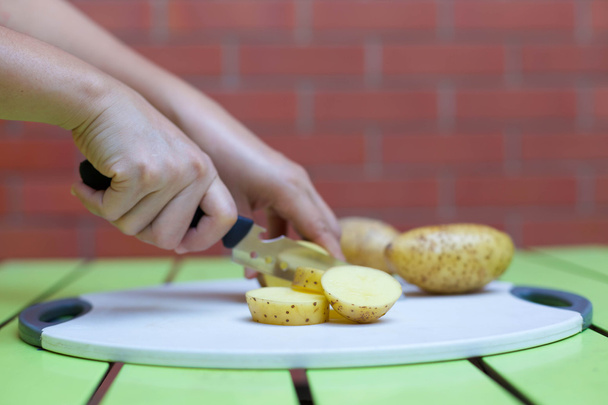 Жінки ріжуть картоплю ножем
 - Фото, зображення