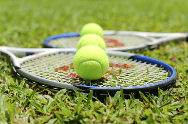 Raquette de tennis avec balles sur l'herbe
 - Photo, image