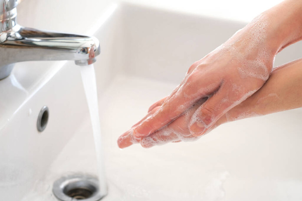 dłoń pięknej kobiety umyć ręce w umywalce z pianką, oczyścić skórę i mieć wodę przepływającą przez ręce. Koncepcje zdrowia i urody - Zdjęcie, obraz