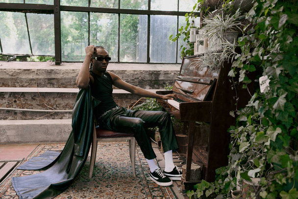 Un homme sophistiqué est assis à côté d'un piano à queue dans un jardin verdoyant animé. - Photo, image