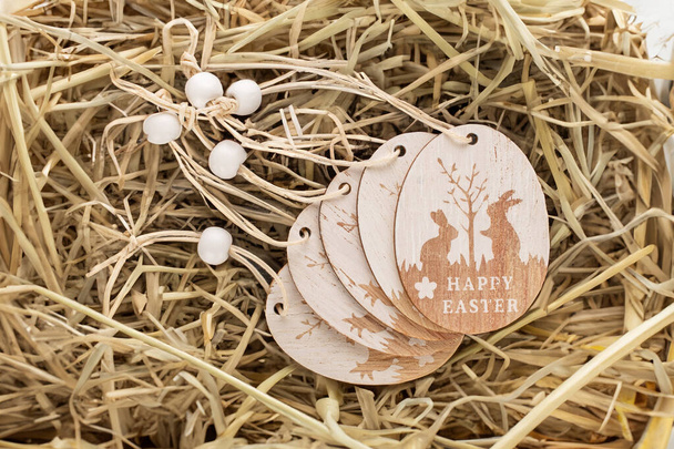 Wooden decoration for Easter on straw, macro, top view. - Photo, Image